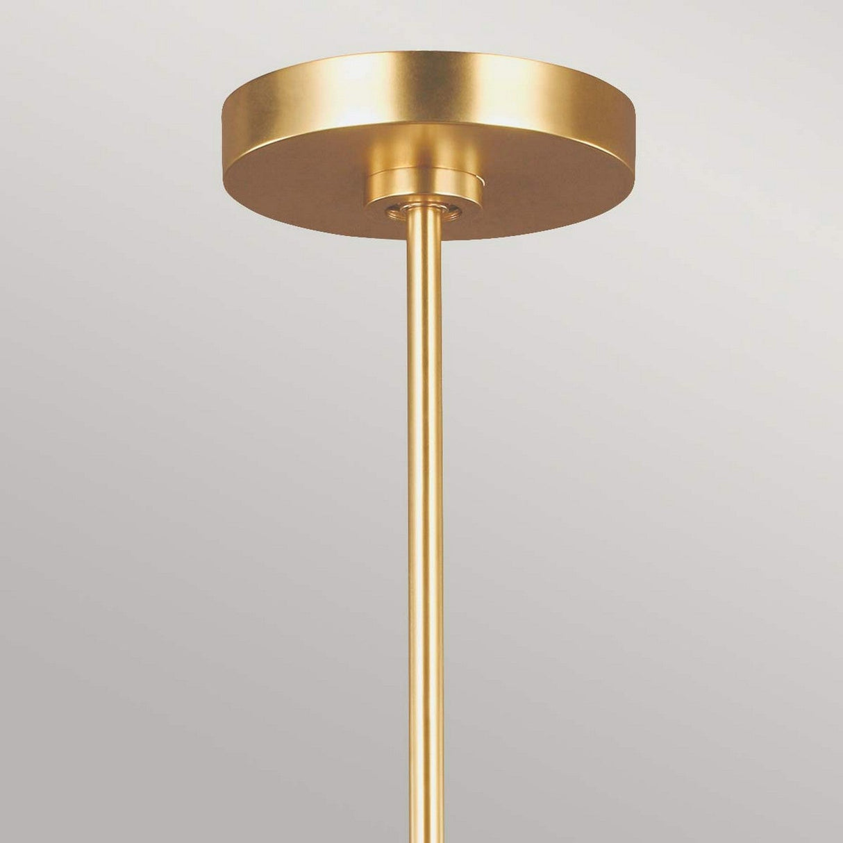 Close-up of the Joan 5 Light Chandelier in Matte White/Burnished Brass, featuring a modern ceiling light fixture. The design highlights a circular base and a slim cylindrical rod extending downward, capturing contemporary elegance.