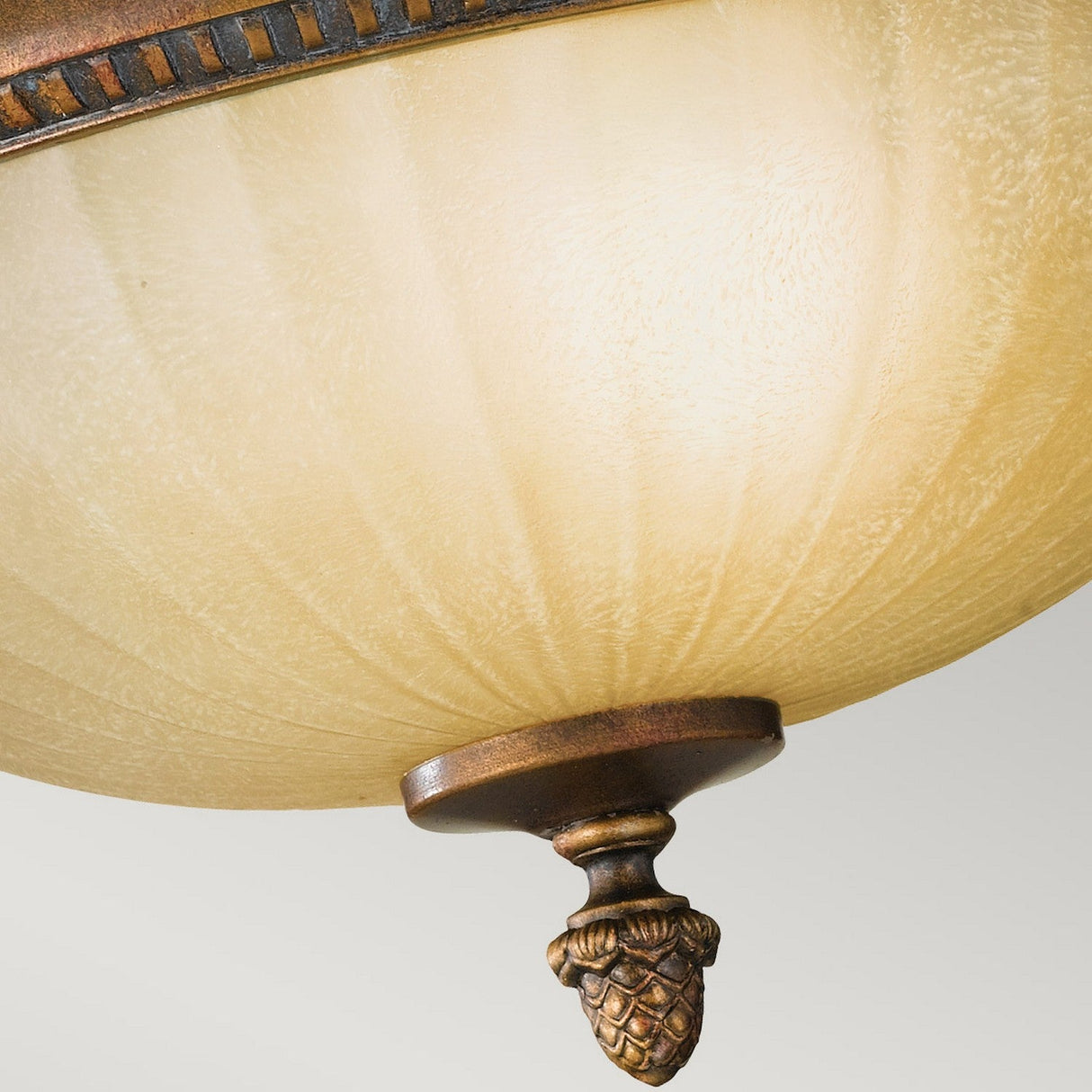 This close-up showcases the Kelham Hall 2 Light Flush ceiling fixture, featuring a frosted glass dome and British bronze detailing, complete with a decorative pinecone-like finial. Its design radiates the warm, antique charm that echoes the timeless elegance of Kelham Hall.