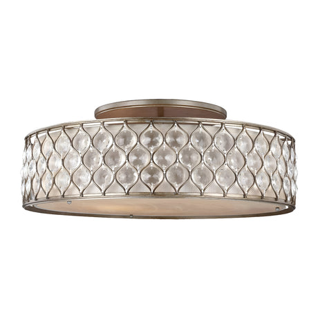 Introducing the Lucia 6 Light Flush - Burnished Silver: This round, ceiling-mounted light fixture showcases a metallic frame with an interlocking teardrop pattern and a burnished silver finish. The outer layer features translucent panels that gently diffuse light, making it an ideal choice for elegant luxury lighting solutions.