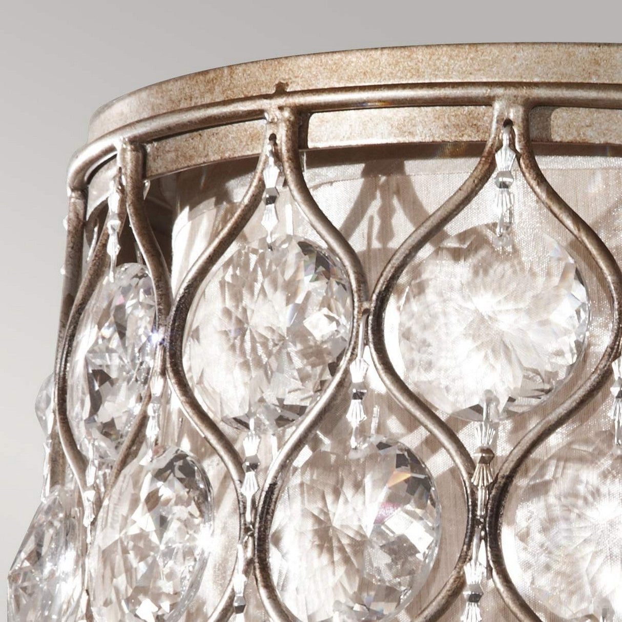 A close-up view of the Lucia 2 Light Flush - Burnished Silver, featuring substantial clear Bauhinia crystals intricately placed in a detailed metallic frame with a burnished silver finish. The crystals are arranged in a repeating pattern that captures and beautifully reflects light.