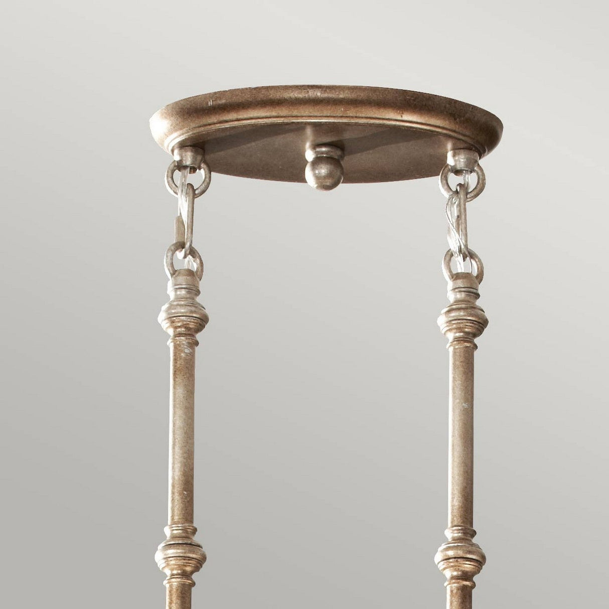 The Lucia 3 Light Large Chandelier - Burnished Silver features a ceiling mount with a decorative metallic plate, two slender rods connected by chains, and an antique finish in burnished silver set against a light gray background. Adorned with Bauhinia crystals, it offers added elegance.