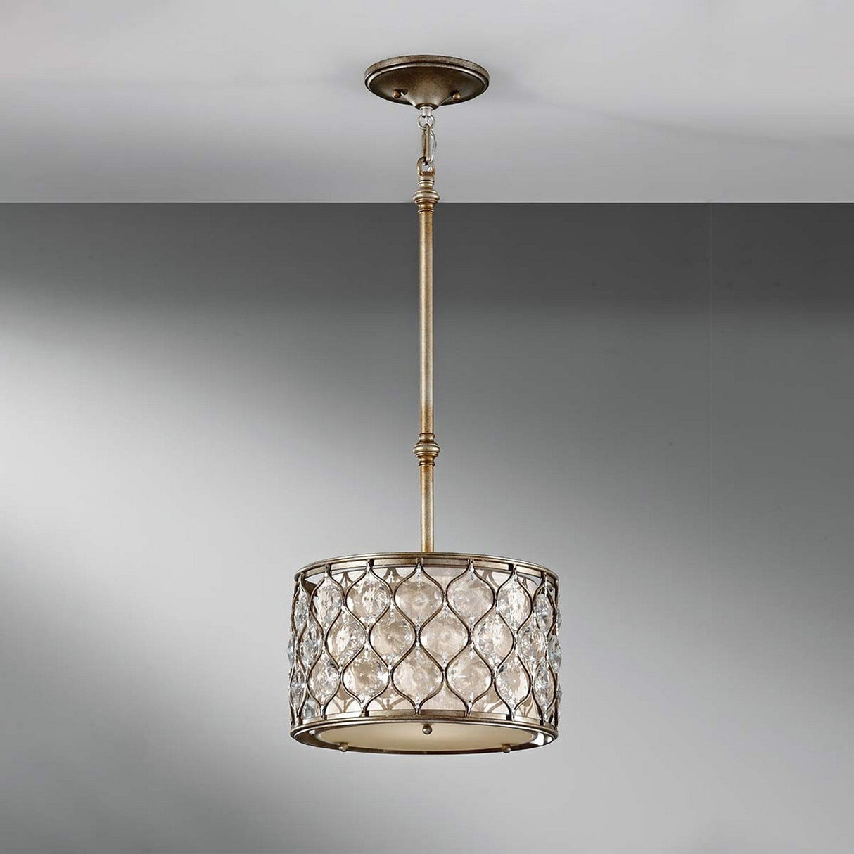 The Lucia 1 Light Pendant Light in a burnished silver finish features a cylindrical cage-style shade, embellished with Bauhinia crystals and glass accents to cast elegant reflections while hanging from the ceiling.