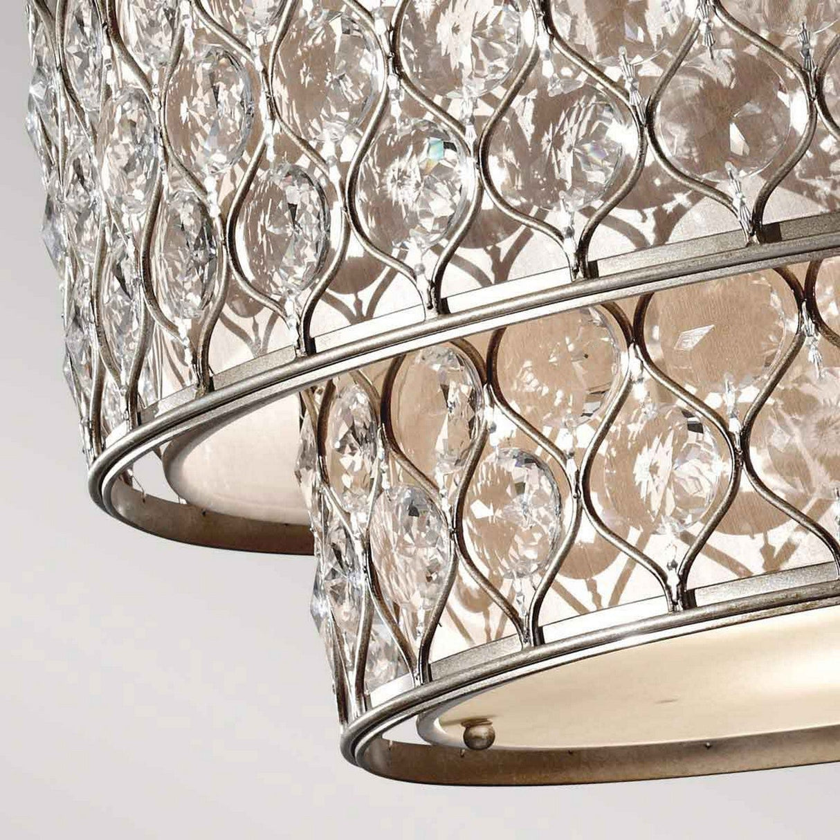 A close-up of the Lucia 6 Light Chandelier in Burnished Silver showcases its elegant and luxurious appearance with sparkling Bauhinia crystals against a neutral background.