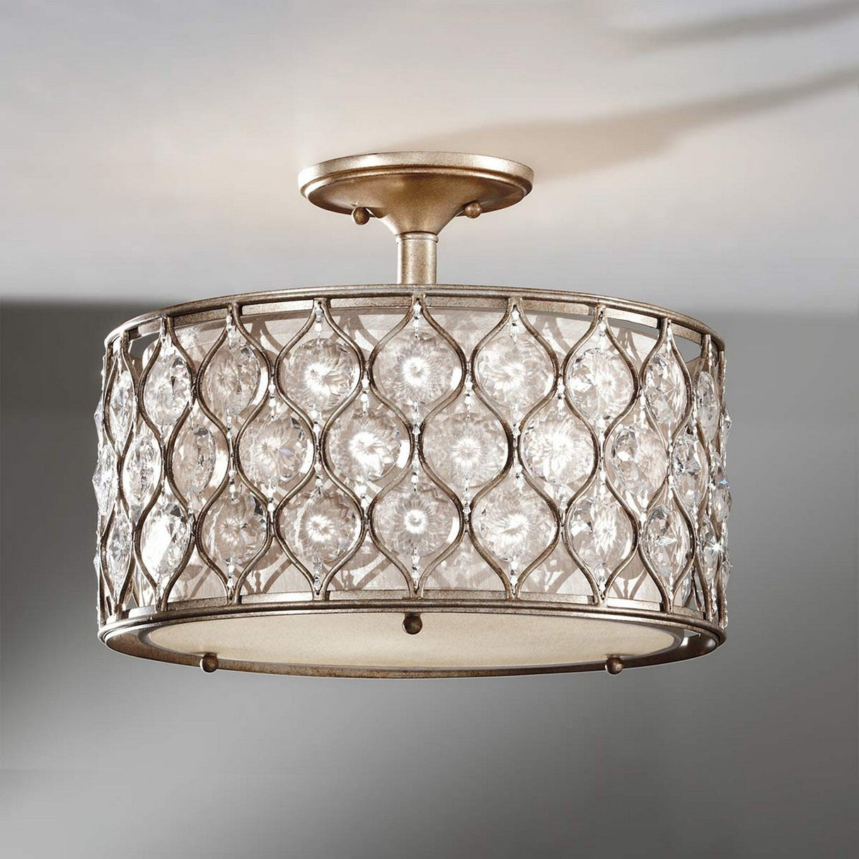 The Lucia 1 Light Semi Flush fixture, with its burnished silver metal frame and Bauhinia crystals, casts a warm and elegant glow. The design is enhanced by diamond-shaped crystal inserts, adding a touch of sophistication to any room.