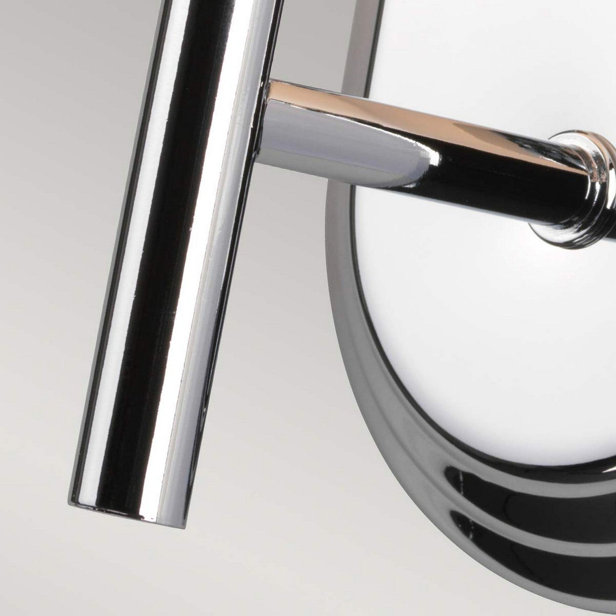 A close-up of a sleek, polished chrome faucet with a modern design is perfectly complemented by the Malibu 1 Light Wall Light in the background, its opal-etched glass emphasizing the shiny, reflective surface of the faucet.