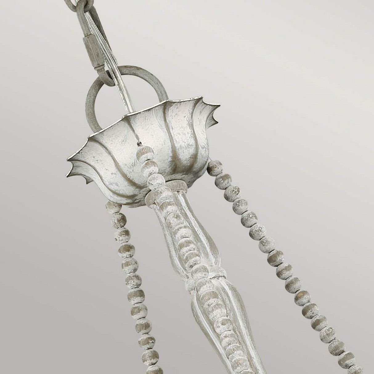 A close-up of an ornate metal hook suspends the Maryville 3 Light Chandelier - Washed Grey, featuring a chain with beaded details that embody French Country elegance against a light gray background.