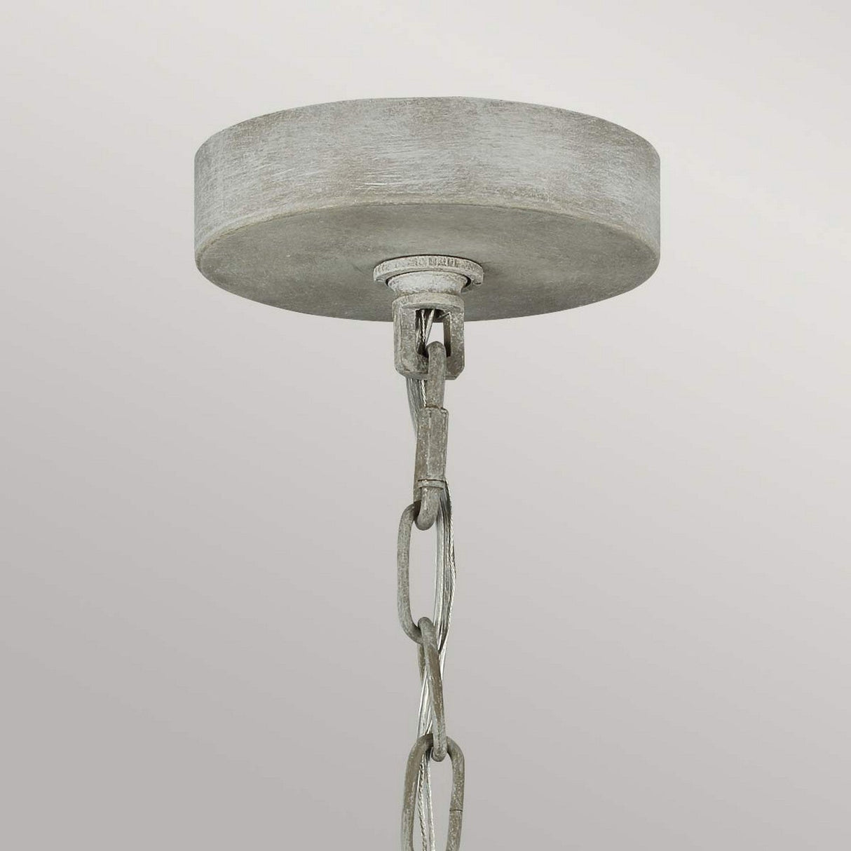 The Maryville 3 Light Chandelier - Washed Grey is a metallic ceiling mount connected with a short chain that centers elegantly. It showcases French Country charm through its brushed, rustic finish complemented by washed grey tones against a simple light gray backdrop.