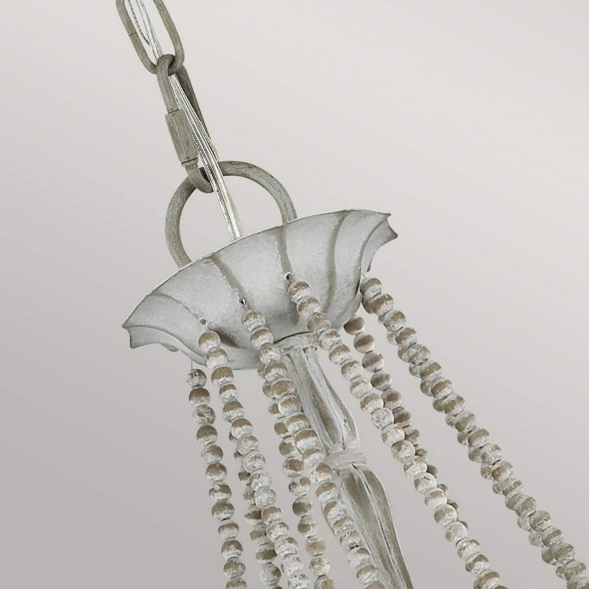 Close-up of the Maryville 9 Light Chandelier - Washed Grey, featuring strings of small, clear beads elegantly draping from a circular metal plate. This piece combines French Country sophistication with a modern touch, suspended by a metal chain against a light gray background.