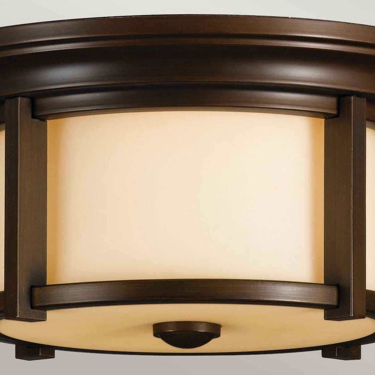 Close-up of the Merrill 2 Light Outdoor Flush - Bronze fixture featuring a round, frosted glass shade and a Heritage Bronze frame. The design boasts clean lines and a contemporary style, seamlessly integrating into various home interiors. Demonstrating elegance with its refined aesthetic, this fixture is suitable for a range of settings.