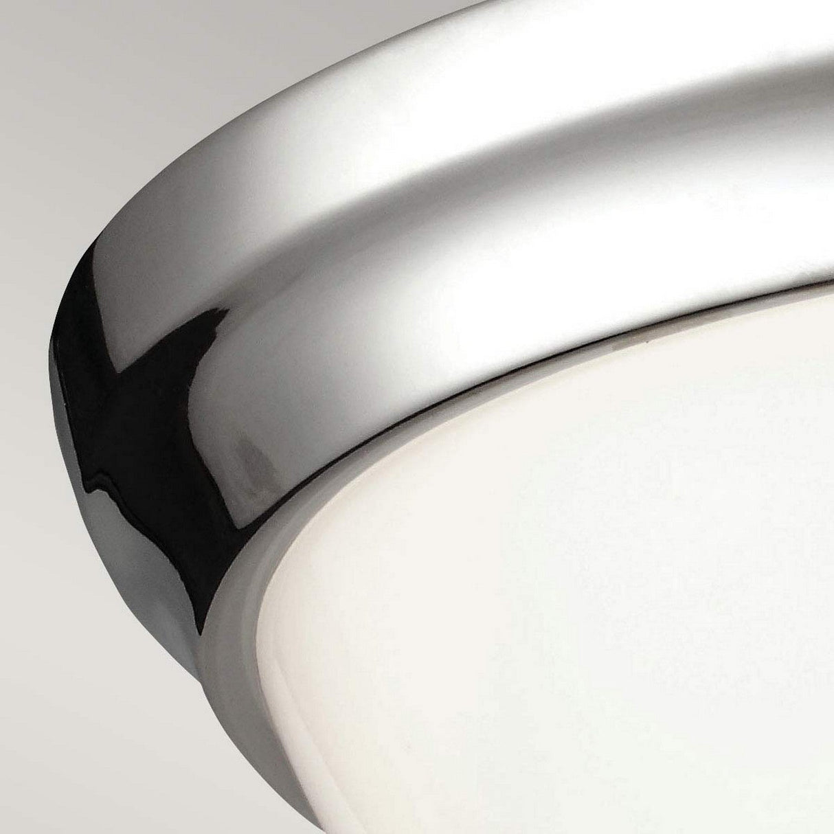 A close-up of the Parkman 2 Light Flush - Polished Nickel ceiling fixture showcases its sleek polished nickel rim and frosted glass cover, embodying a minimalist design against a neutral background.