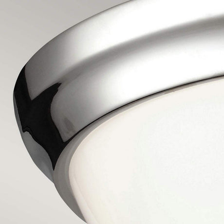 A close-up of the Parkman 2 Light Flush - Polished Nickel ceiling fixture showcases its sleek polished nickel rim and frosted glass cover, embodying a minimalist design against a neutral background.