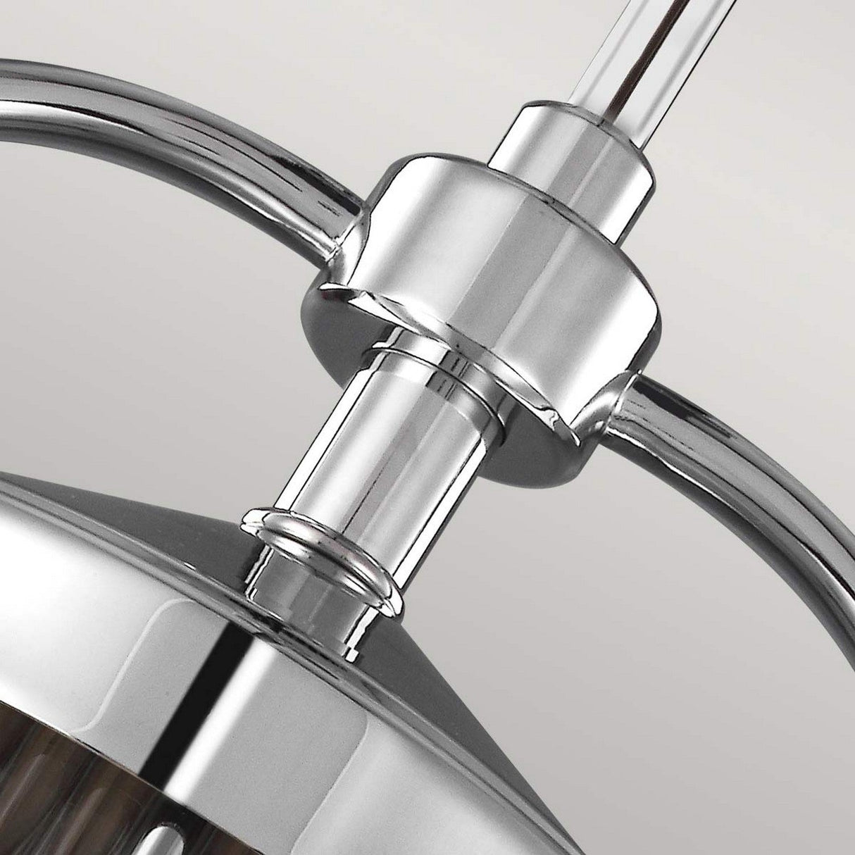 Close-up of the Paulson 3 Light Pendant - Chrome, showcasing its sleek and modern design with shiny chrome elements, featuring curved and cylindrical details against a plain background.