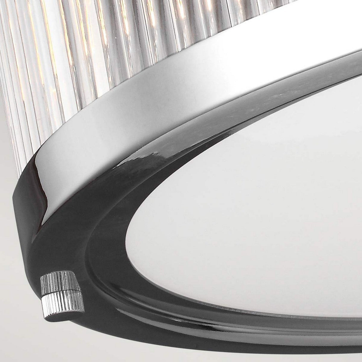 A detailed view of the Paulson 3 Light Flush - Chrome ceiling fixture shows off its polished chrome accents and clear glass rods. Its circular, minimalist design enhances any modern space with a sleek touch.