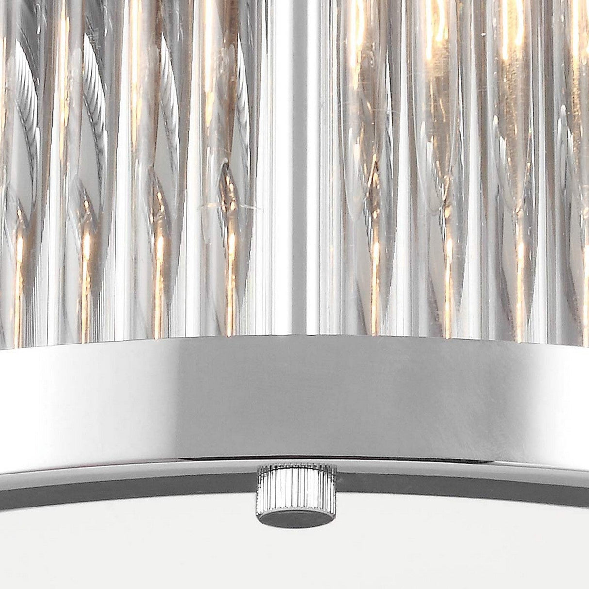 The Paulson 2 Light Flush - Chrome features a modern design with vertical, cylindrical glass rods and a sleek chrome-finished base. When illuminated, the rods cast a warm light downward, and at the center of this flush mount design is a small adjustment knob.