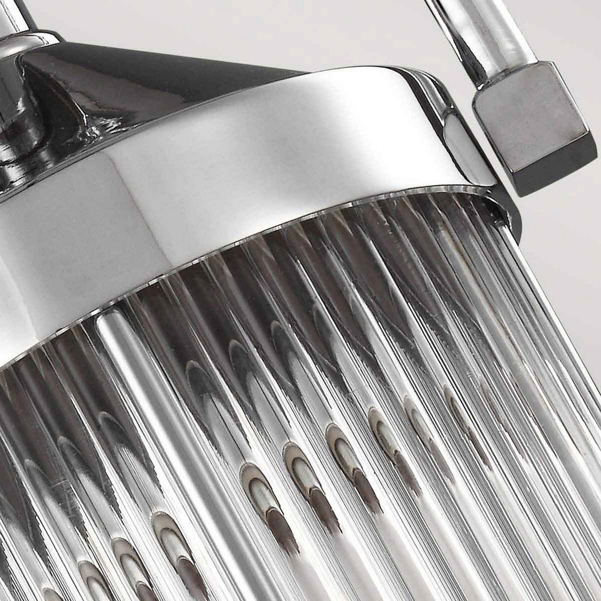 Close-up of a modern, metallic showerhead with multiple small water nozzles and a chrome finish. The surface is shiny and reflects light, highlighting its sleek, contemporary design reminiscent of the Paulson 1 Light Mini Pendant - Chrome's elegance.