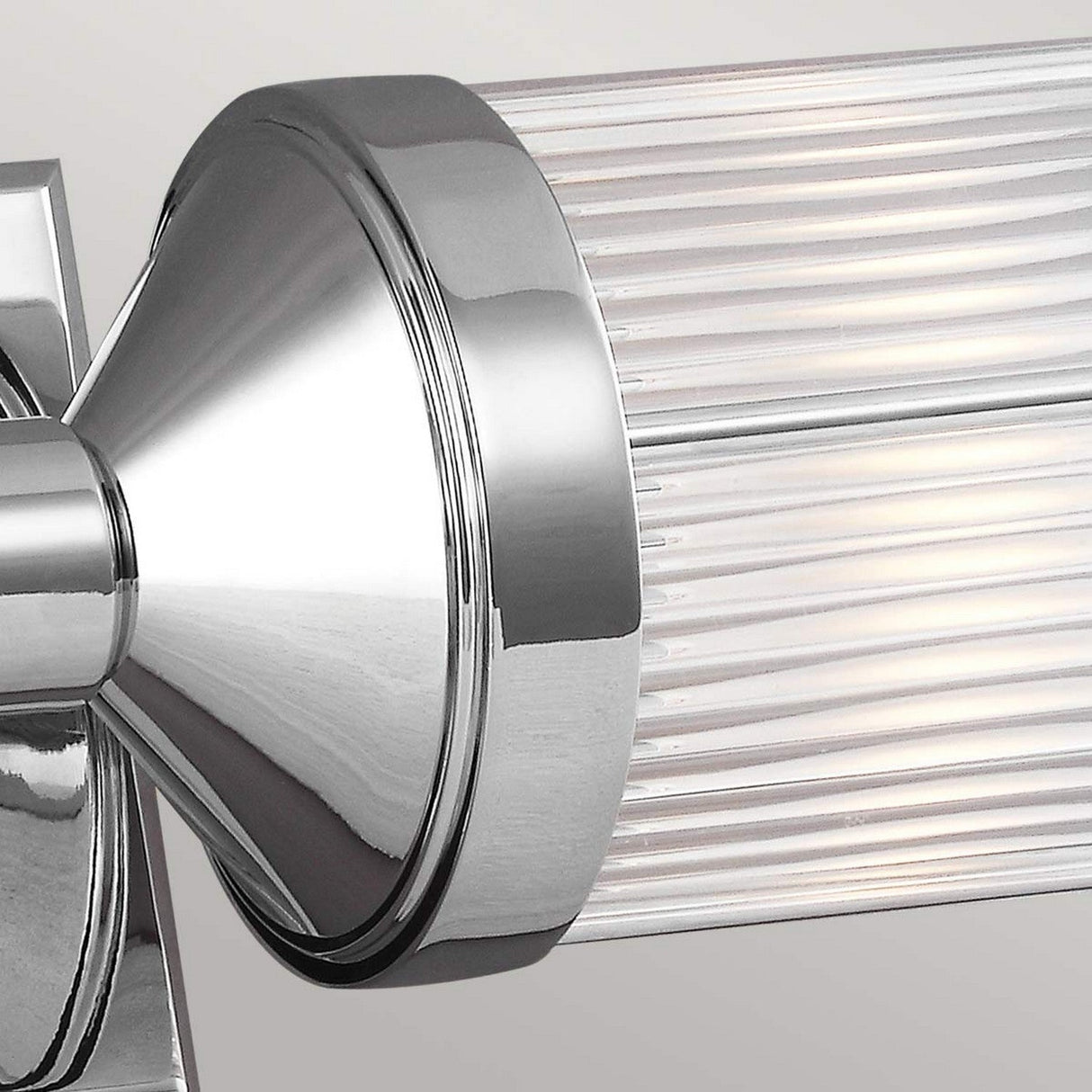 Close-up of the Paulson 2 Light Bar Light in chrome, showcasing its modern cylindrical glass shade with vertical ridges. The sleek, reflective design enhances contemporary decor styles while infusing a touch of vintage lighting into any space.