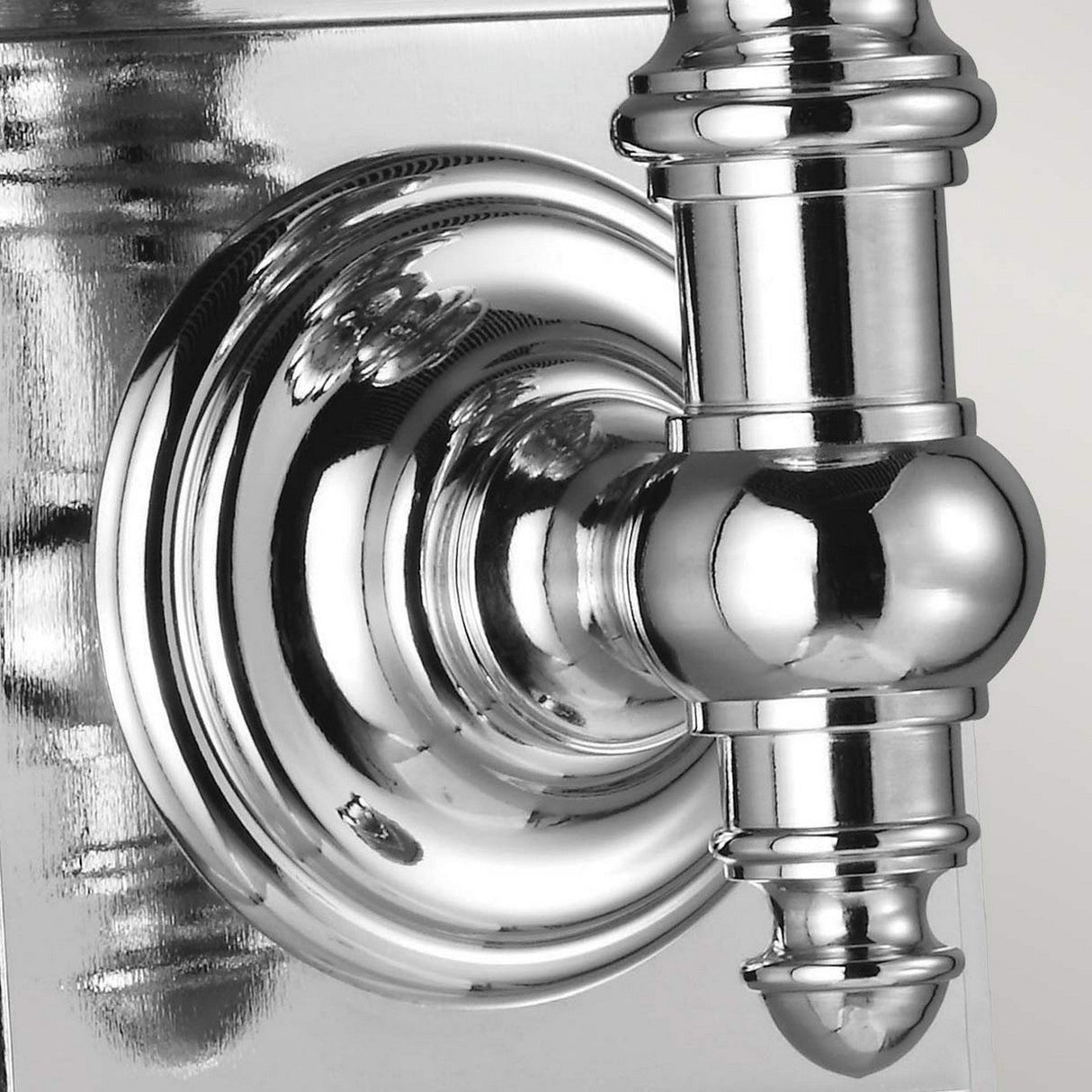 Here is a close-up of the Payne-2 1 Light Wall Light in polished chrome, showcasing its sleek round plate and cylindrical hinge. The elegant chrome finish reflects its surroundings against a light gray background, creating partial reflections.