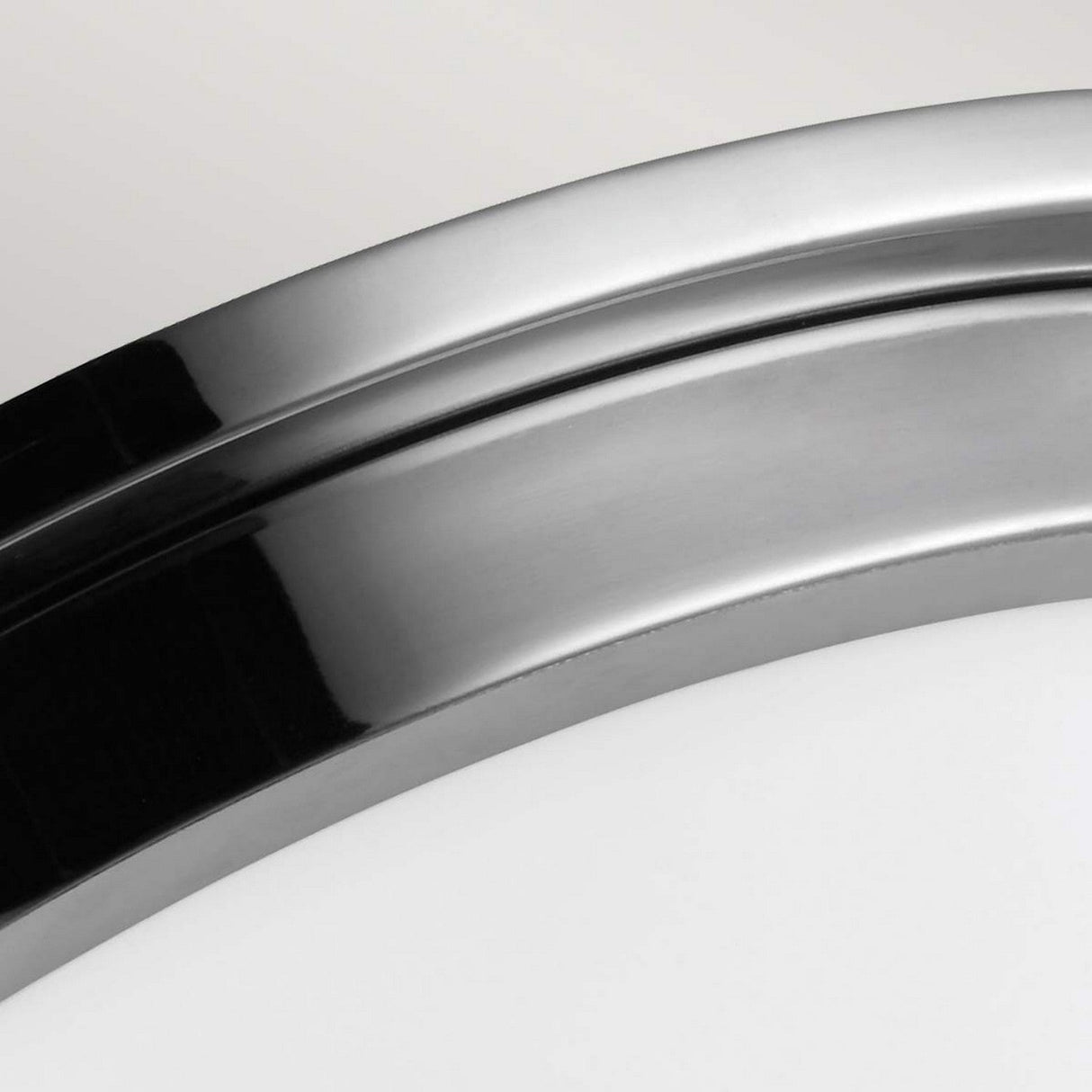 Close-up of the Payne 2 Light Flush with its sleek, curved polished chrome frame set against a plain background. The shiny surface reflects light, emphasizing its smooth finish and flush design.