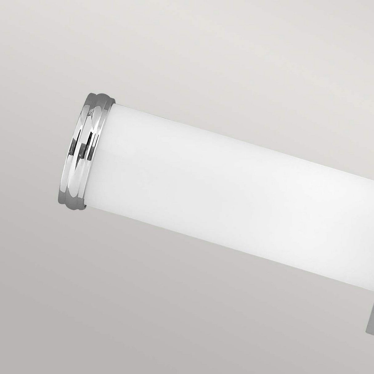 Close-up of the Payne-2 2 Light Wall Light - Polished Chrome, featuring a cylindrical white shade and polished chrome finish on the metallic end caps, set against a plain, soft gray background.
