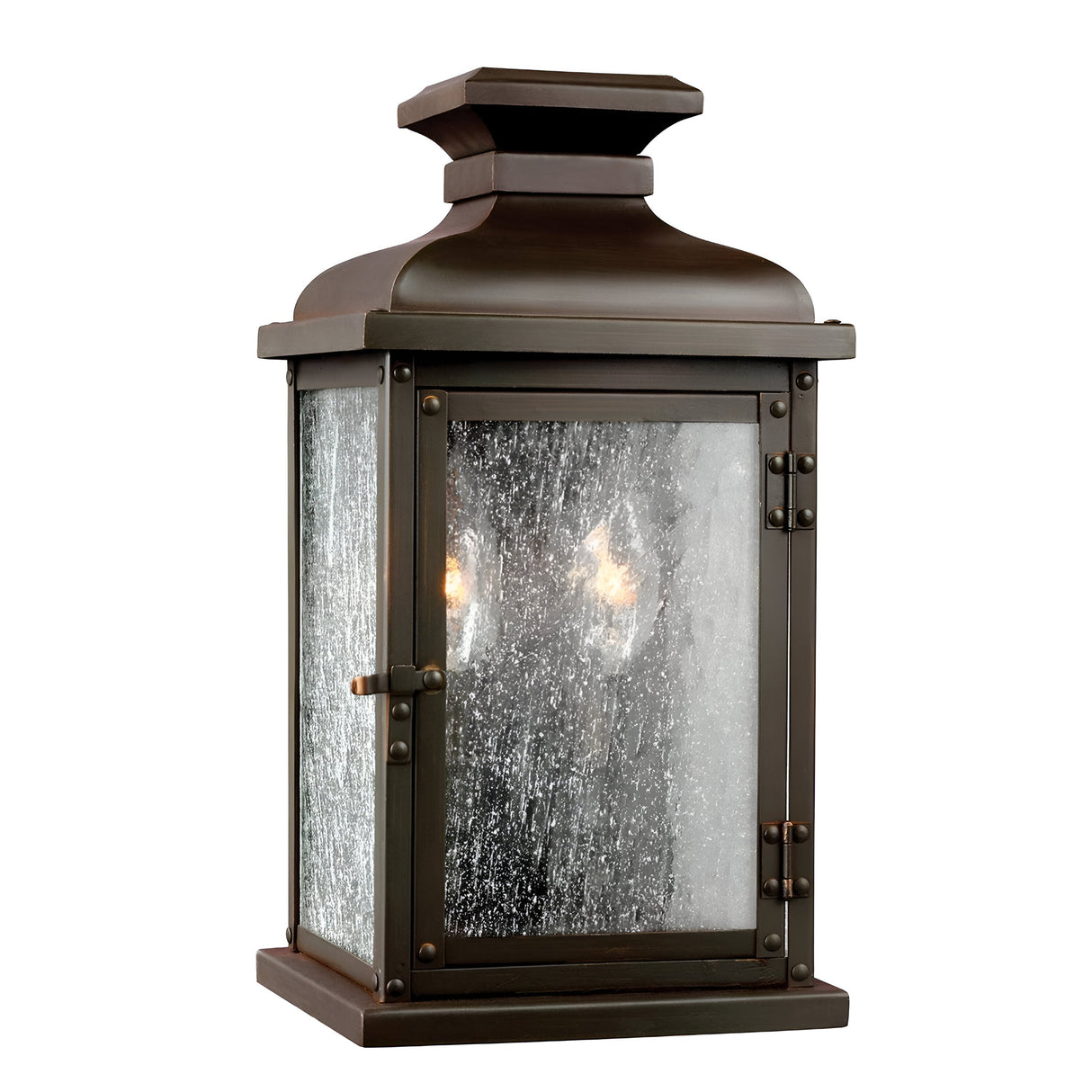 The Pediment 2 Light Outdoor Small Wall Lantern in dark copper boasts a rustic, rectangular design with clear, seeded glass panels that reveal the luminous light bulbs within. Its traditional, vintage style makes it ideal for exterior lighting.