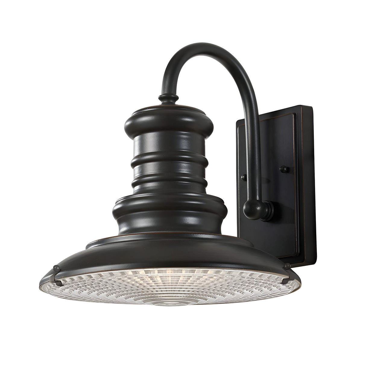 The Redding Station 1 Light Outdoor Medium Wall Lantern in dark bronze is a vintage-style fixture featuring a curved arm and round, ribbed glass shade. Its classic design is perfect for illuminating exteriors, while the weather-resistant construction and rectangular backplate ensure both style and durability.