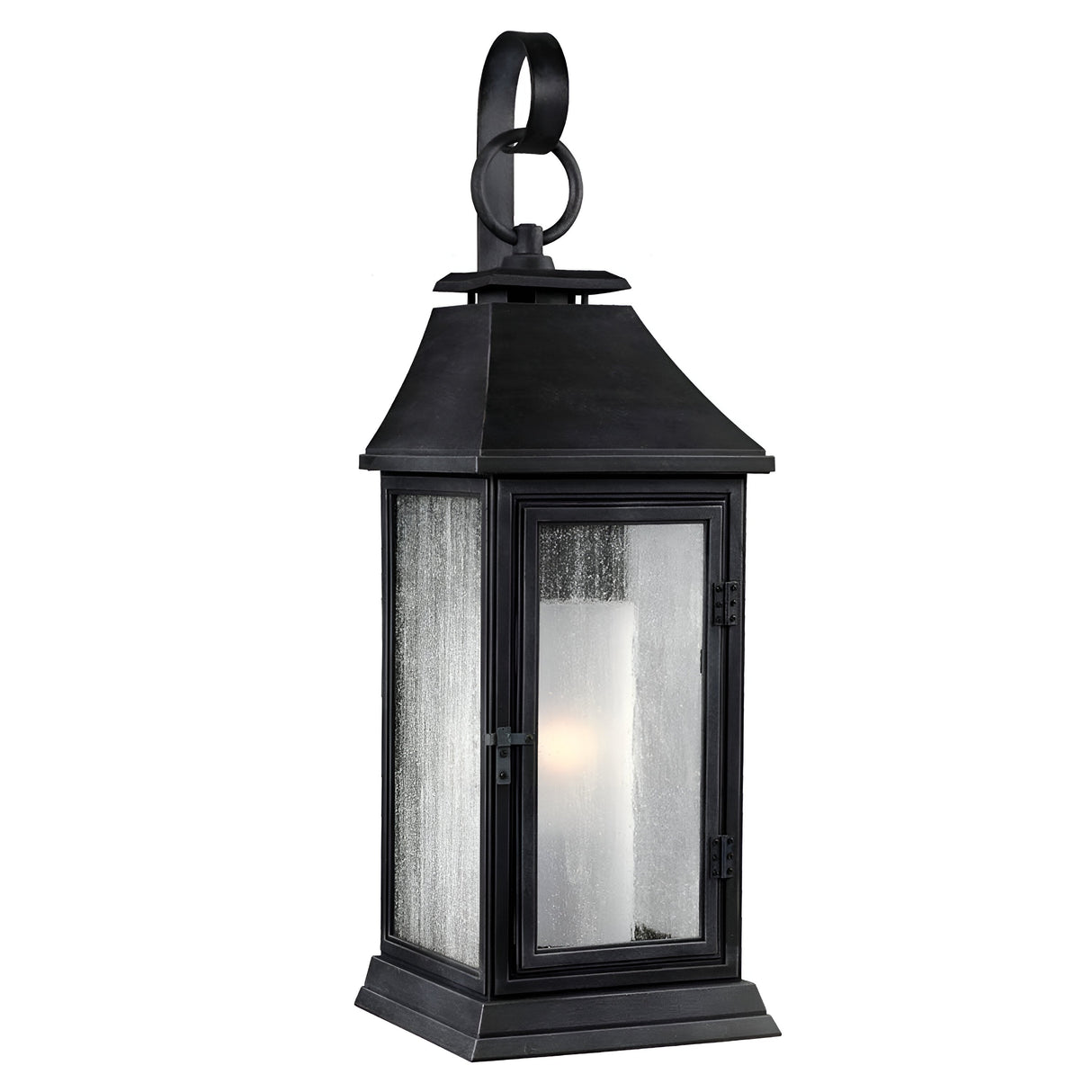 The Shepherd 1 Light Outdoor Small Wall Lantern in Dark Weathered Zinc offers a classic, vintage outdoor lighting design with its tall, rectangular shape and loop handle on top. It features glass panels that house a cylindrical light bulb inside, providing a warm glow. This weather-resistant lantern is crafted from black metal.