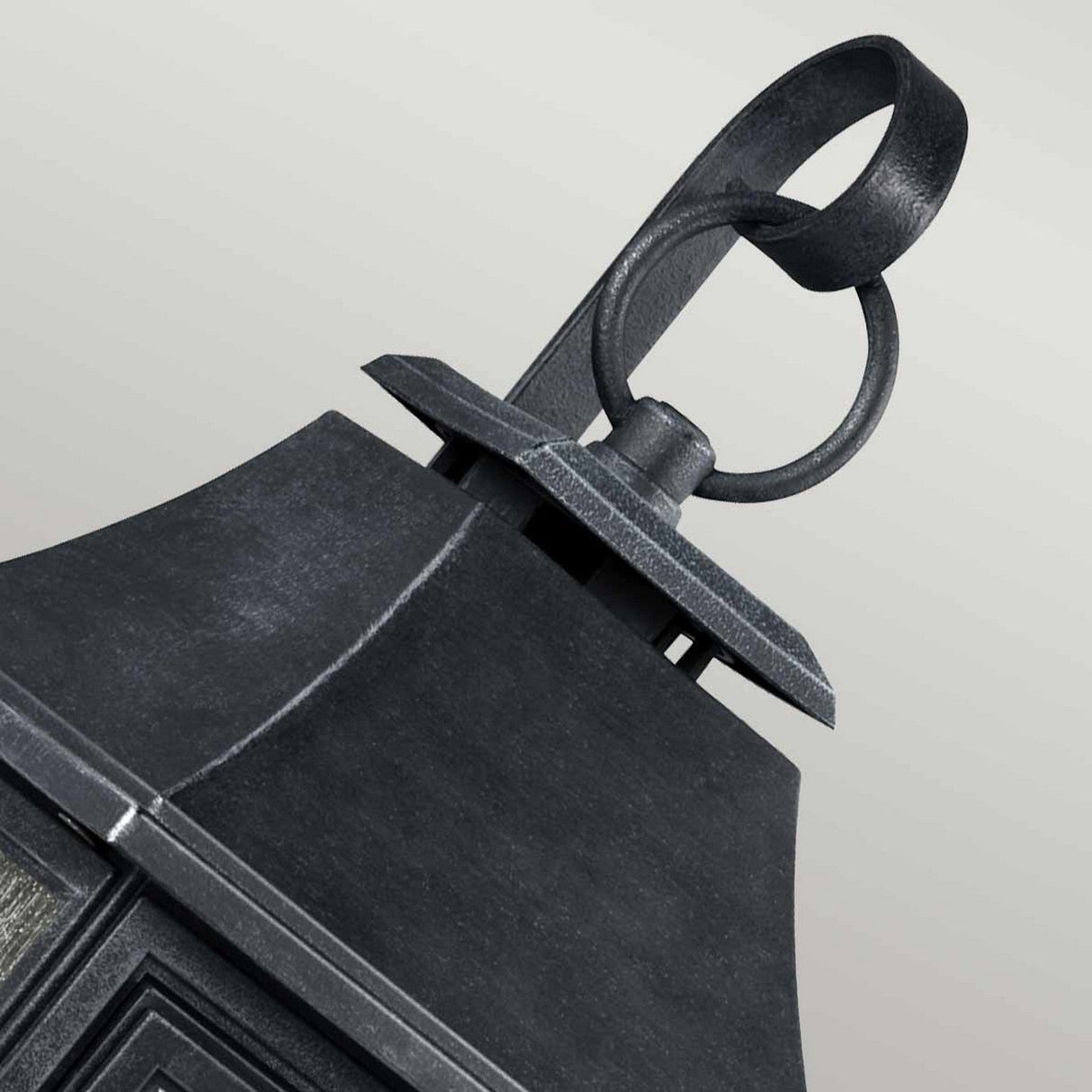 Close-up of the Shepherd 1 Light Outdoor Extra Large Wall Lantern in Dark Weathered Zinc, showcasing its ornate design with a curved handle on top. Made from weather-resistant composite material, it features a textured surface and rectangular shape against a plain, light gray background.