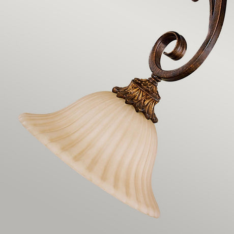 A close-up of the Sonoma Valley 1 Light Mini Pendant showcases a swirled bronze arm and a fluted, cream glass shade. The ornate design boasts intricate details and rustic elegance, set against a soft grey background.