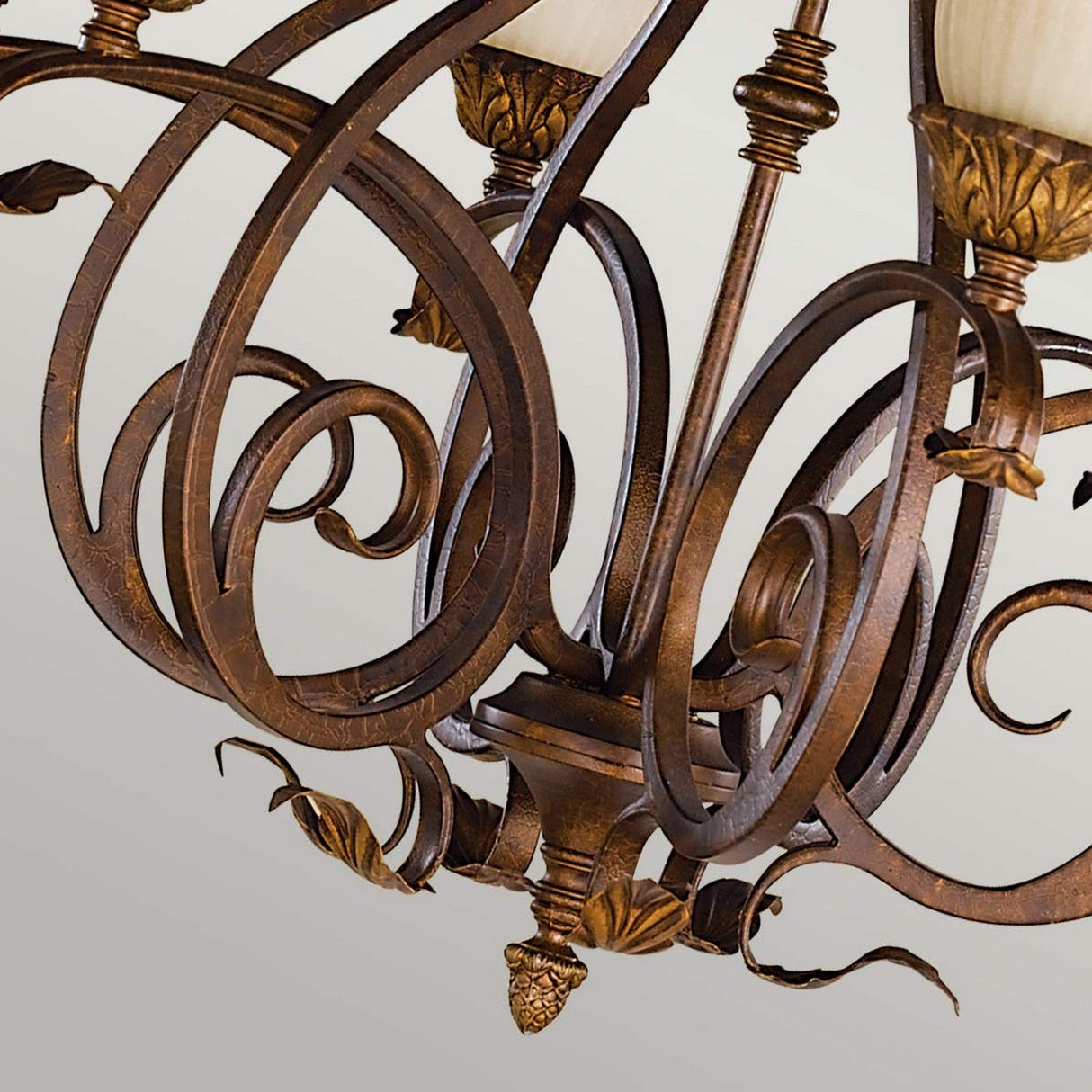 Close-up of the Sonoma Valley 6 Light Chandelier - Cream/Bronze, showcasing intricate bronze scrollwork and leaf motifs with opal glass shades. The elegant curves embody a French Country antiques style, adding a sophisticated and classic touch against a neutral background.