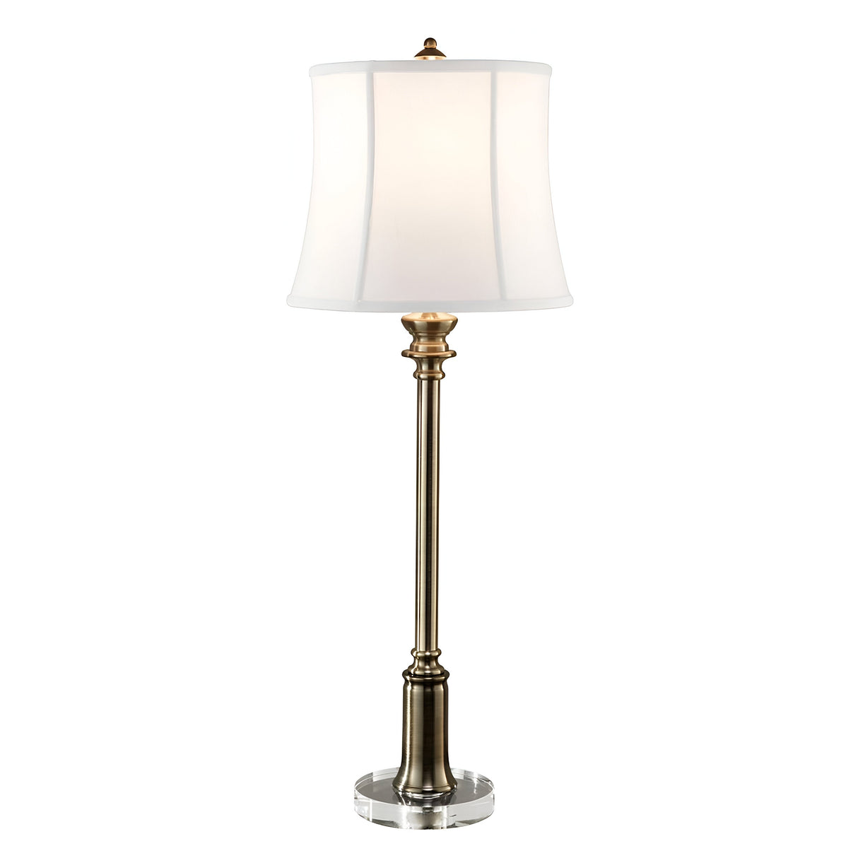 The Stateroom 1 Light Buffet Lamp - Brass is a tall, elegant lamp featuring a classic design with a brass finish on the base and stem. It has a round, transparent base and is complemented by a slightly flared white cotton linen shade. The lamp is currently turned off.