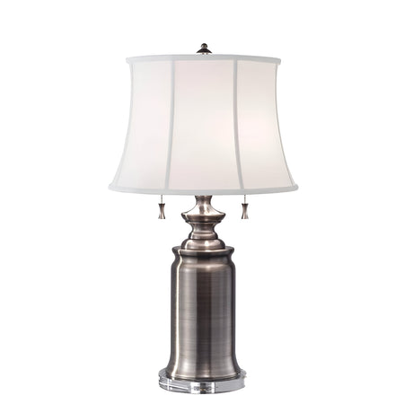 The Stateroom 2 Light Table Lamp - Antique Nickel features a sophisticated silver design with a white, slightly tapered cotton linen shade. Its antique nickel base provides a modern flair, while two pull chains offer flexible lighting control.