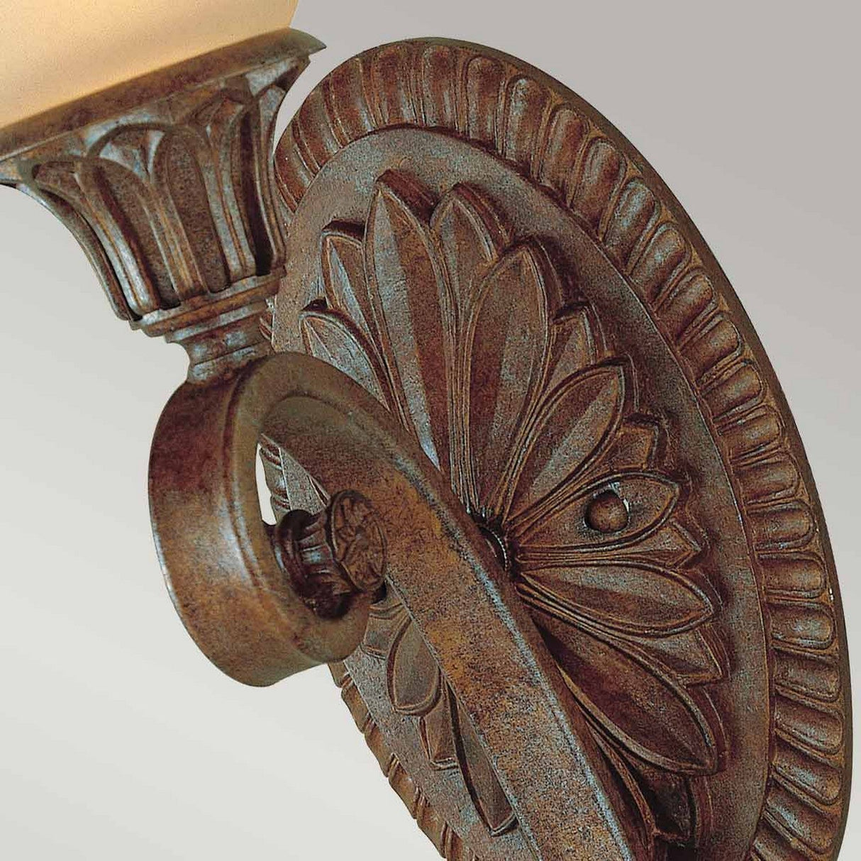 Here's a rewritten version of the sentence using the given product data:
A close-up of the Stirling-1 Castle 1 Light Wall Light in Bronze showcases this decorative wall sconce's vintage allure with its floral design and elegant rust-colored finish. The sconce features a light fixture with a cream-colored glass shade set against a simple gray background.