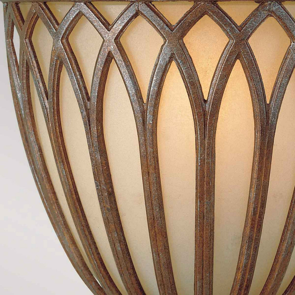 The Stirling-2 Castle 1 Light Wall Light - Bronze boasts an elegant and ornate design with intersecting metal arches that create a geometric pattern over warm, glowing frosted glass. Its traditional style is further accentuated by the bronze finish, offering a touch of timeless sophistication.