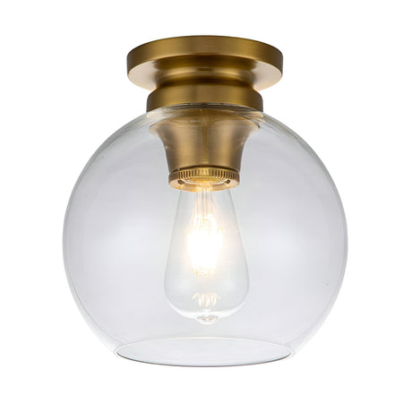 The Tabby 1 Light Flush - Burnished Brass features a burnished brass finish and a clear glass shade. Inside, an exposed bulb casts a warm glow against the white background, creating an inviting ambiance.