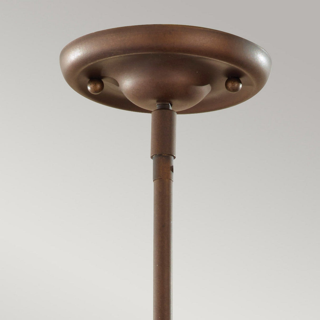A vintage-style lighting piece, the Urban Renewal 3 Light Large Pendant in bronze features a simple, round design with a slender rod extending downward, perfect for showcasing Edison bulbs against a plain gray background.