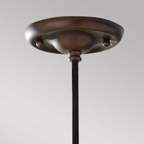 A detailed view of the Urban Renewal 1 Light Pendant in bronze features an industrial pendant light design with a dark cord hanging below. The ceiling canopy showcases a smooth, rounded shape and matte finish against a plain, light gray background. An Edison-style bulb provides just the right touch of nostalgia.