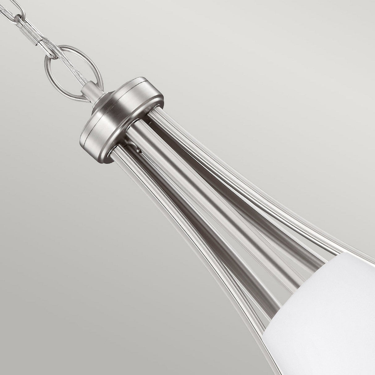 Close-up of a contemporary pendant light fixture finished in satin nickel. It showcases a tapered, elongated design with opal etched glass shades at the base, suspended by a chain against a neutral backdrop, evoking the style of the Vintner 5 Light Chandelier - Satin Nickel.