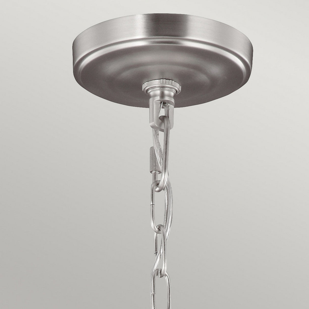 A close-up of a brushed metal ceiling canopy with a chain attached, showcasing its elegant Satin Nickel finish. The plain light gray background accentuates the refined details that enhance the Vintner 5 Light Chandelier - Satin Nickel.