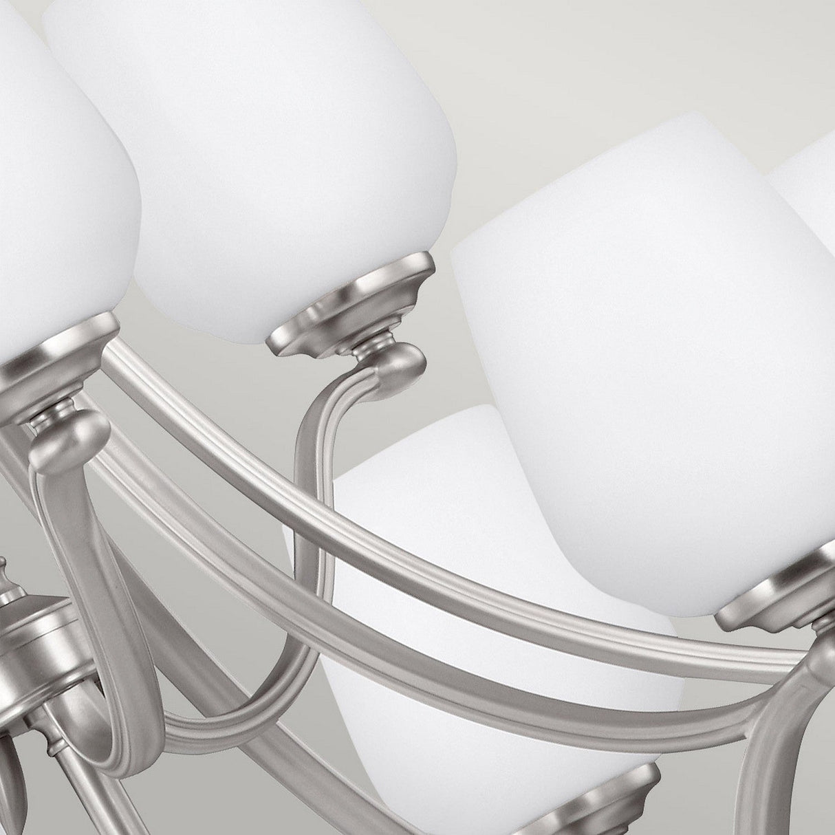 Close-up of the Vintner 9 Light Chandelier in Satin Nickel, featuring a sophisticated design with multiple satin nickel arms extending gracefully from a central point, each adorned with frosted opal etched glass shades.