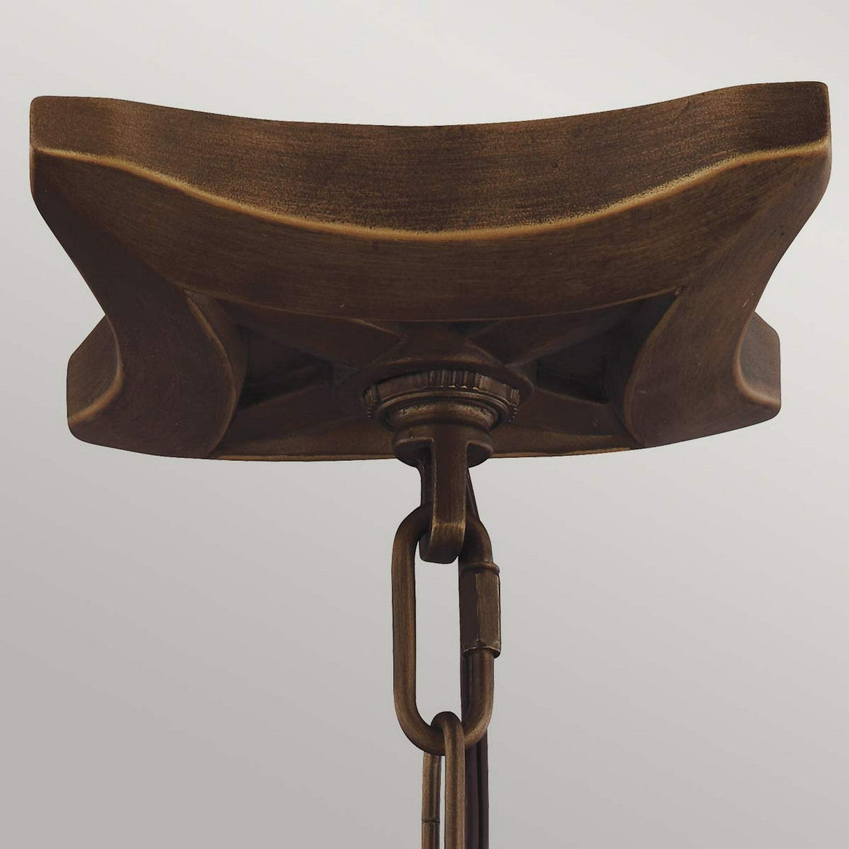 Close-up of the Yarmouth 3 Light Chandelier, a rustic, square ceiling fixture in painted aged brass with a chain attachment. Its surface exudes vintage charm reminiscent of traditional lantern styles against a neutral background.