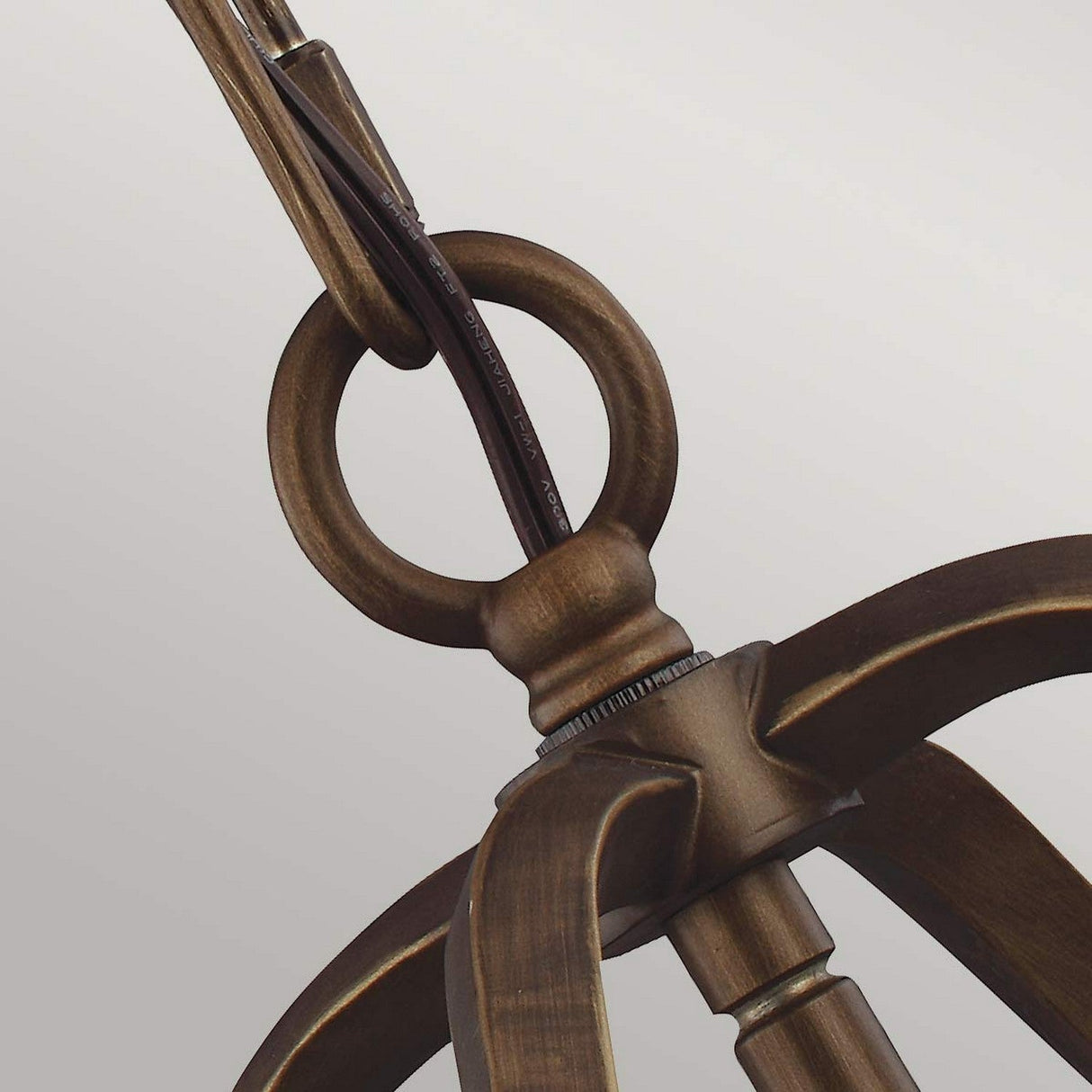 Close-up of the Yarmouth 3 Light Chandelier in painted aged brass. The fixture has a classic design with a loop and curved arms, set against a plain white background with the electrical cord visible.