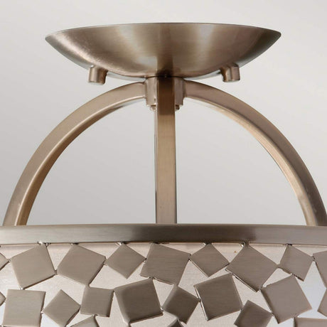Close-up of the Zara 3 Light Semi Flush- Brushed Steel ceiling fixture highlighting its contemporary design. This modern piece is adorned with a brushed steel finish and a decorative square pattern, featuring an arched support structure that is elegantly complemented by a mosaic-like element encircling the light casing.