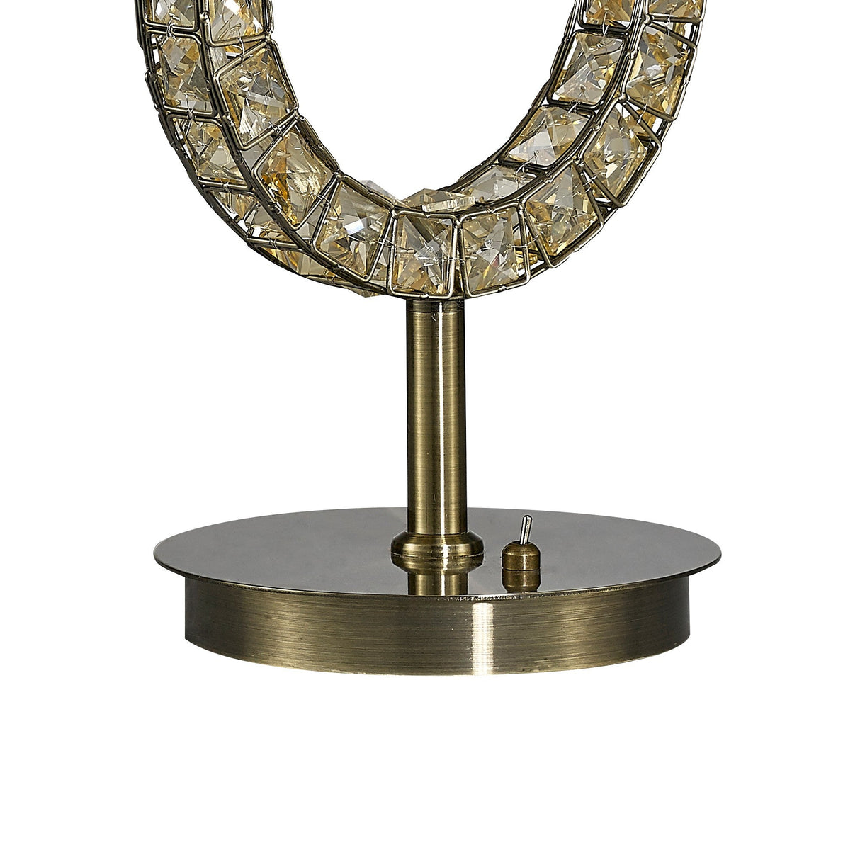 A close-up of the Florence Round 1 Light Crystal Table Lamp’s brass base features a circular frame with embedded clear crystals and a small cylindrical switch, set against a plain white background.