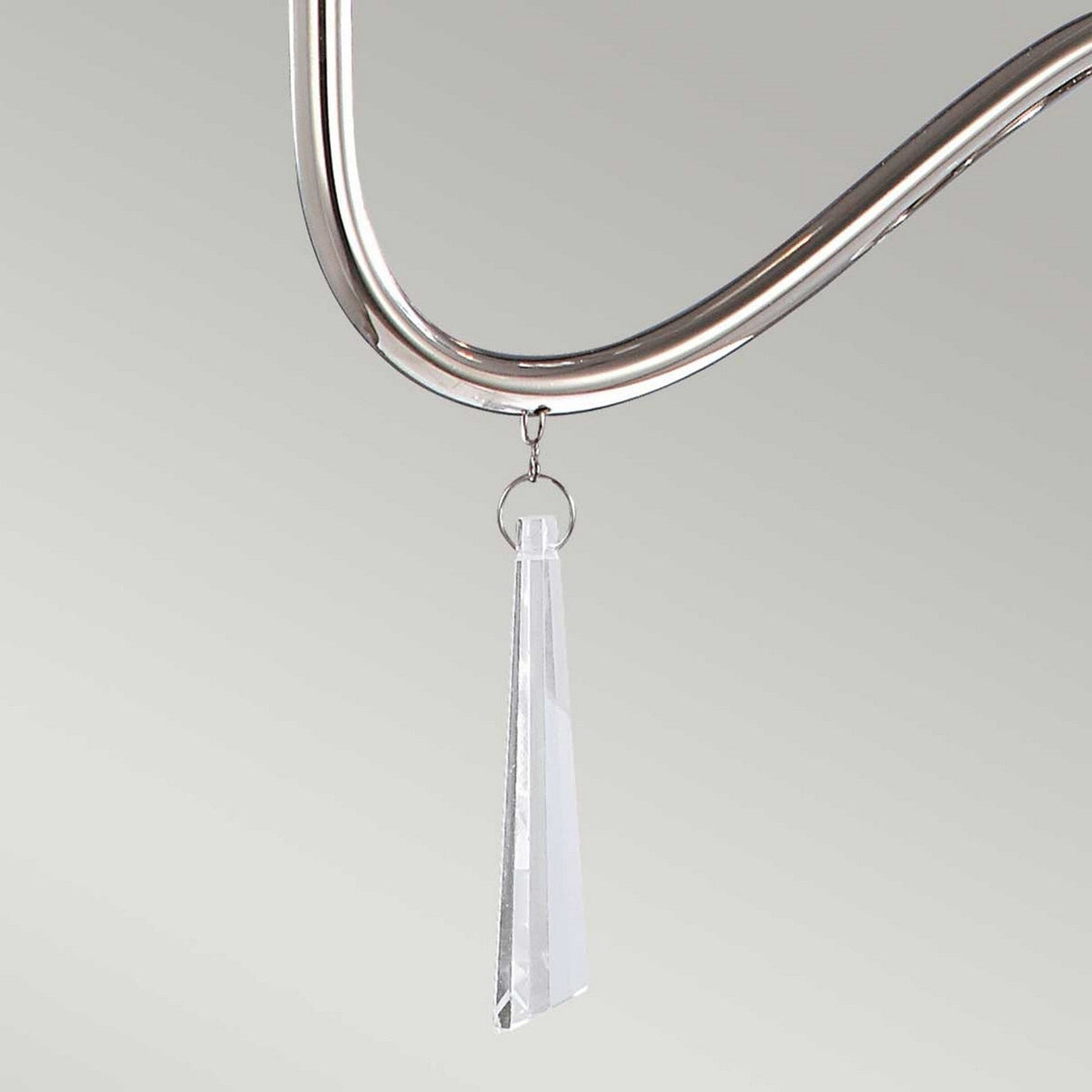 Close-up of the Finsbury Park 3 Light Chandelier in polished nickel, featuring a sleek frame with faceted, transparent crystal pendants. The handmade design adds elegance against the neutral, light gray background.