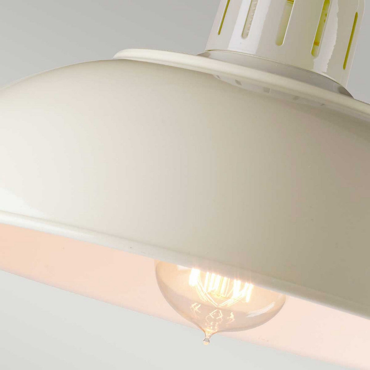 Close-up of the Franklin Desk Lamp in white, featuring a glowing incandescent bulb ideal for task lighting in modern interiors, set against a light gray background.