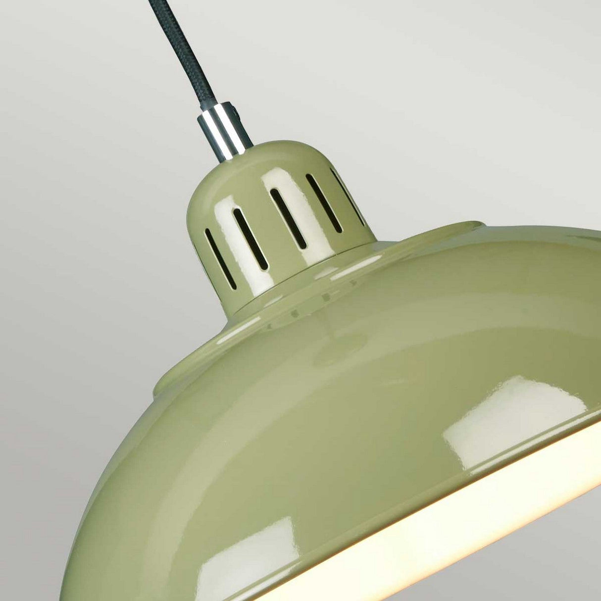 Close-up of the Franklin Pendant Light - Green, exhibiting a glossy finish and a black cord against a light gray background. This industrial-style task lighting fixture includes slotted vents at the top for heat dissipation, highlighting its retro-inspired charm.