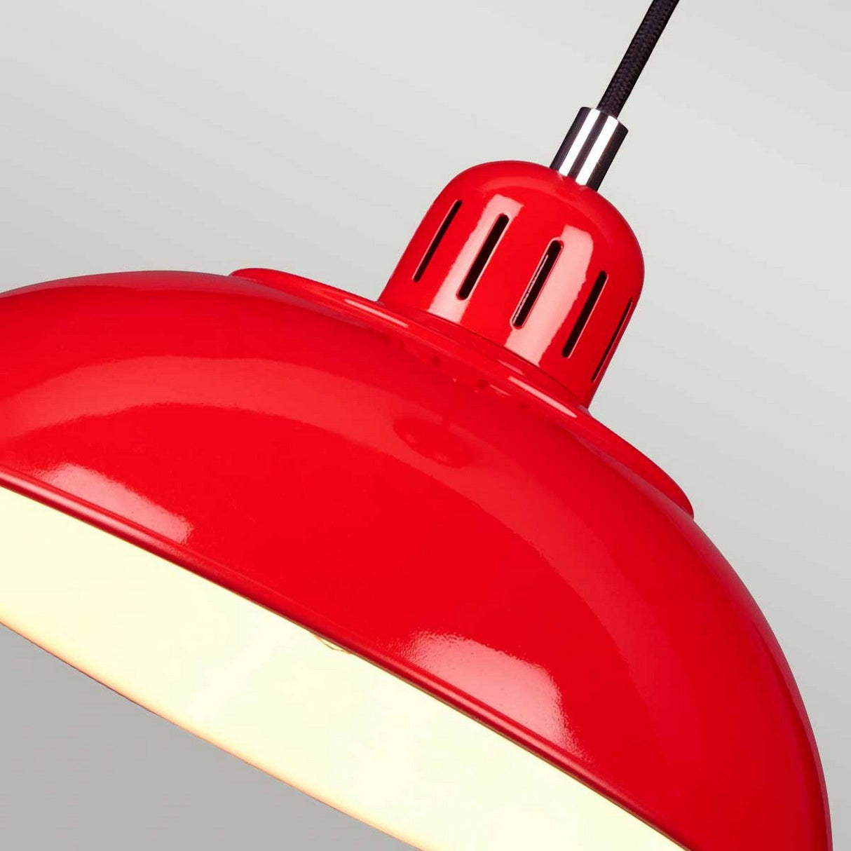 A close-up view of the Franklin Pendant Light- Red, featuring a vibrant red dome-shaped shade with a glossy finish. It's suspended from a black cord against a light gray background, providing subtle task lighting with some illumination visible at its bottom edge.