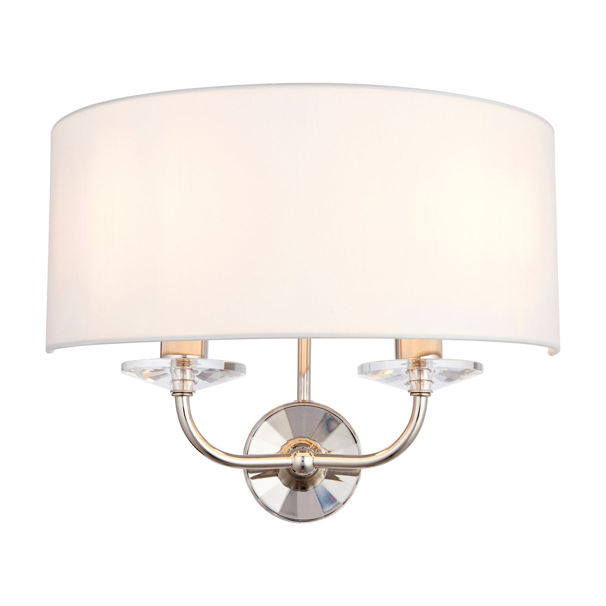 Gallery Direct Ostwyn 2-light wall fitting with white half-drum fabric shade, polished nickel twin arms and clear crystal accents on a plain background.