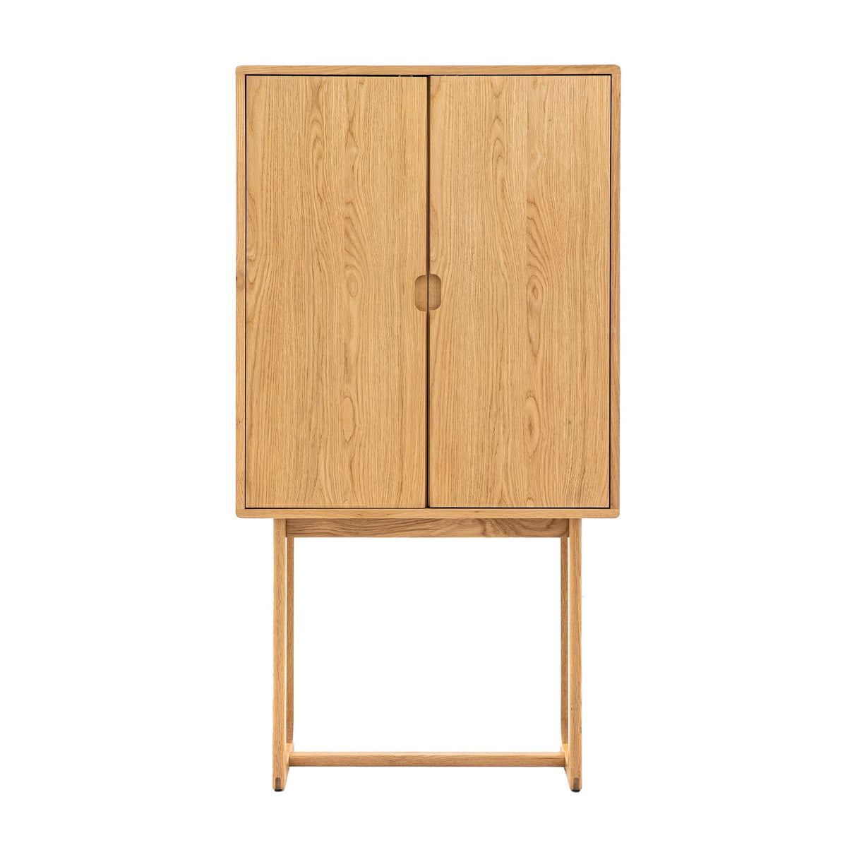 Gallery Direct Craft Cocktail Cabinet in natural oak, tall two-door drinks cabinet with recessed pull and sled-style legs on a white background.