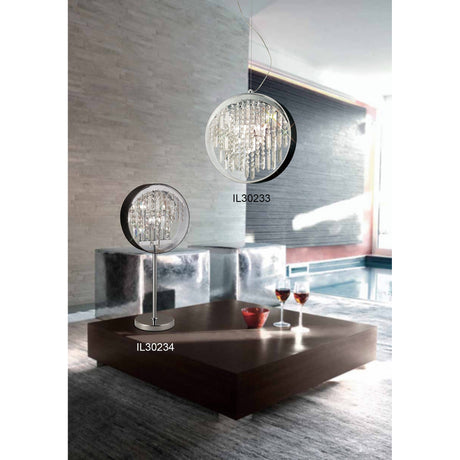 Modern living room with a large wooden coffee table, two glasses of red wine, and striking crystal and metal light fixtures—including the modern statement lamp IL30233 on the ceiling and the Geo Crystal 7 Light Table Lamp - Polished Chrome (IL30234) on the table.